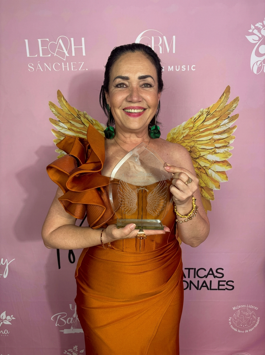 Xóchitl Lagunes recibiendo un reconocimiento con alas doradas